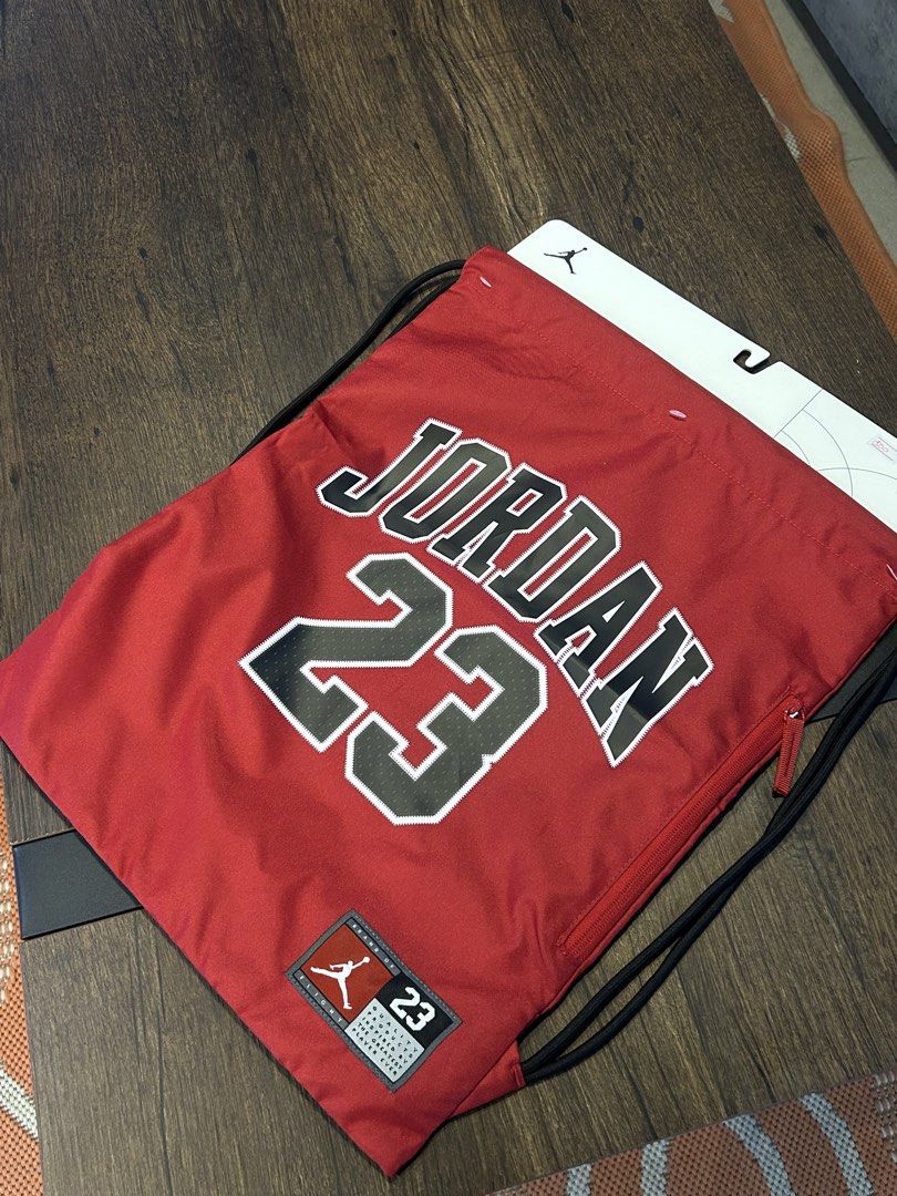 Jordan 23 Red Drawstring Bag (Category: Backpacks) located in San Fernando. Submitted by aljames1623 (Listing ID 1469284211, Image 2). Description: - Authentic Jordan drawstring backpack in striking red - Features iconic number 23 branding - Convenient side zipper pocket for extra storage - Durable black cord straps - Brand new with tag still attached - Perfect for casual wear, gym, or travel.