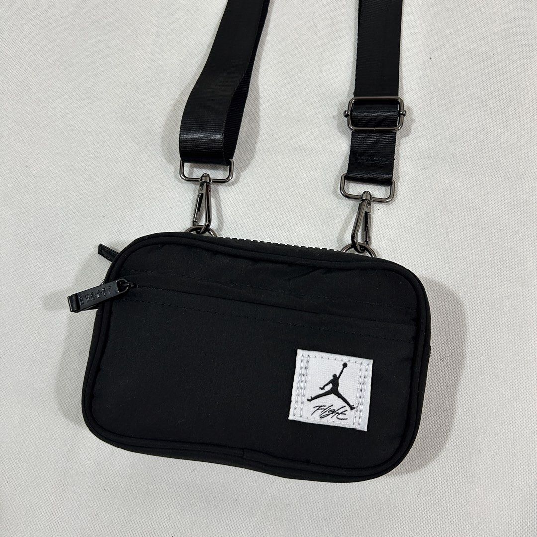 Jordan Flight Black Crossbody Bag (Category: Sling Bags) located in Cavite. Submitted by moo2k (Listing ID 1469204067, Image 2). Description: - Brand: Jordan Flight - Color: Classic black with white Flight patch - Material: Durable fabric construction - Compartments: Main zip compartment, smaller front pocket, and interior zippered pocket - Details: Woven Jordan logo patch inside - Strap: Adjustable shoulder strap with sturdy metal clips - Condit