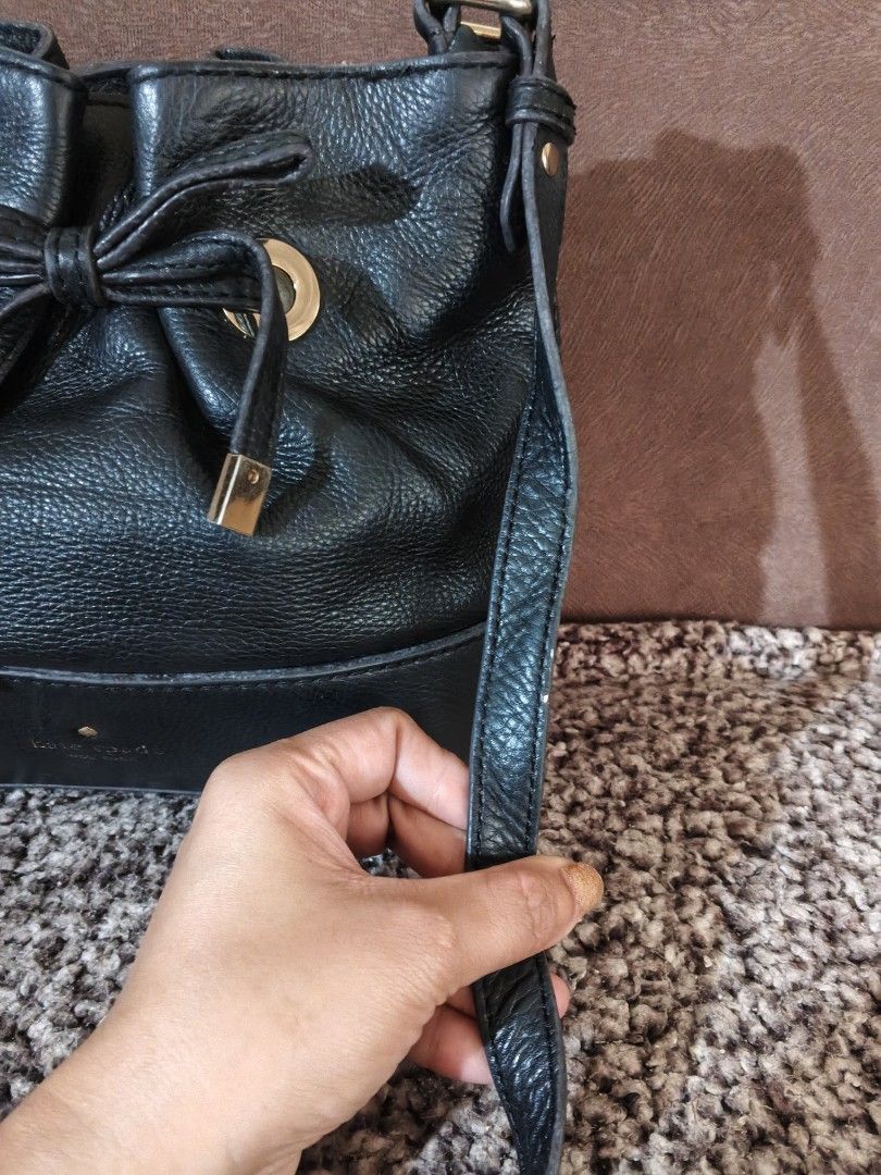 Kate Spade Black Leather Bucket Bag (Category: Luxury Bags & Wallets) located in Bulacan. Submitted by shayneerri02343 (Listing ID 1469173981, Image 3). Description: - Brand: Kate Spade New York - Material: Genuine black pebbled leather with gold-tone hardware - Closure: Drawstring with a stylish front bow detail - Strap: Long, adjustable crossbody strap - Design: Structured base with metallic logo lettering and a clean interior lining - Capacity