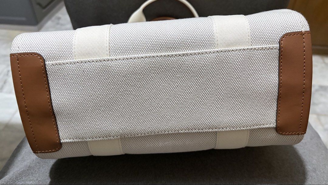 Kate Spade New York Canvas Small Tote (Category: Tote Bags) located in Quezon City. Submitted by bella_ciao (Listing ID 1469260989, Image 3). Description: - Authentic Kate Spade canvas tote bag in neutral cream - Brown leather trim with bold black lettering on the handles - Includes a matching detachable shoulder strap for versatile styling - Features the iconic signature spade charm hanging on the front - Secure zip top closure to keep your belo
