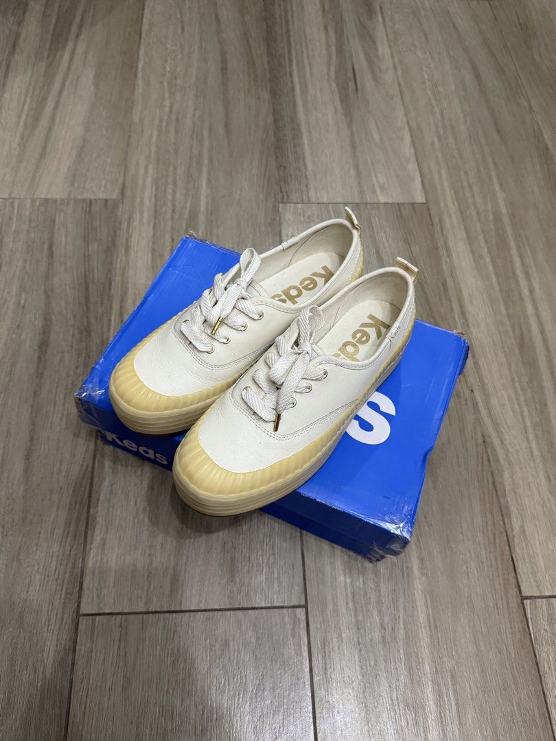 Keds Platform Sneakers White Cream (Category: Sneakers) located in Makati City. Submitted by the.archives (Listing ID 1469200124, Image 1). Description: - Brand: Keds Platform Sneakers - Color: White with cream rubber soles and bumpers - Size: US 6.5 or EU 37 - Material: Premium leather upper with heel pull tabs - Details: Gold aglets, gold branding on insoles, and embroidered side heel tags - Sole: Chunky design with textured sidewalls - Packagi
