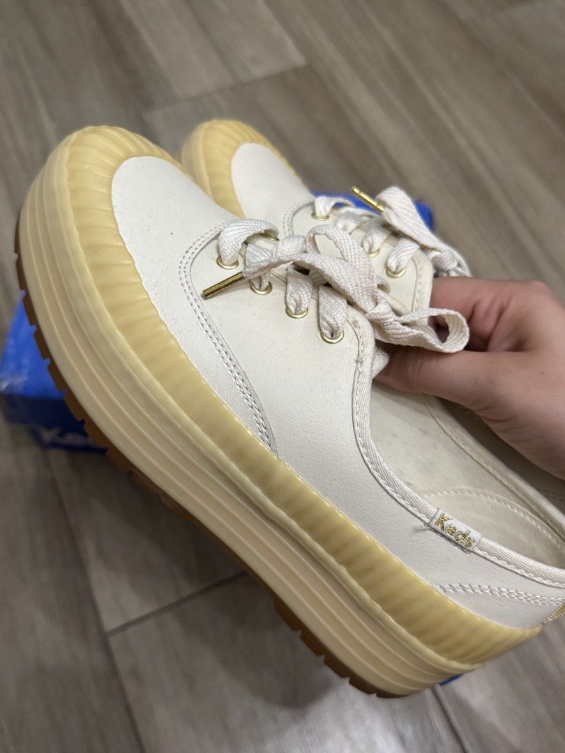 Keds Platform Sneakers White Cream (Category: Sneakers) located in Makati City. Submitted by the.archives (Listing ID 1469200124, Image 2). Description: - Brand: Keds Platform Sneakers - Color: White with cream rubber soles and bumpers - Size: US 6.5 or EU 37 - Material: Premium leather upper with heel pull tabs - Details: Gold aglets, gold branding on insoles, and embroidered side heel tags - Sole: Chunky design with textured sidewalls - Packagi