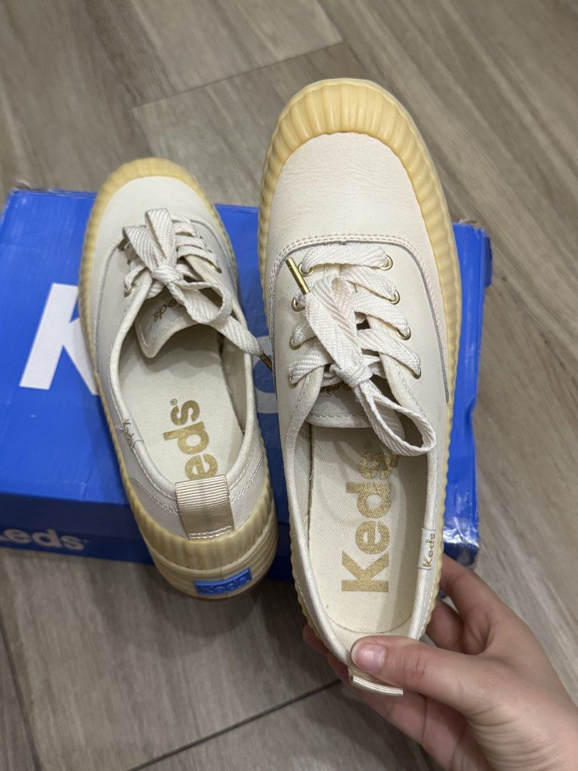 Keds Platform Sneakers White Cream (Category: Sneakers) located in Makati City. Submitted by the.archives (Listing ID 1469200124, Image 3). Description: - Brand: Keds Platform Sneakers - Color: White with cream rubber soles and bumpers - Size: US 6.5 or EU 37 - Material: Premium leather upper with heel pull tabs - Details: Gold aglets, gold branding on insoles, and embroidered side heel tags - Sole: Chunky design with textured sidewalls - Packagi