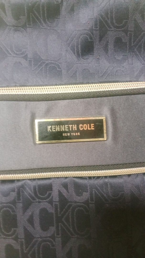 Kenneth Cole New York Monogram Print Navy Backpack (Category: Backpacks) located in San Miguel. Submitted by chriswajer65155 (Listing ID 1469233076, Image 2). Description: - Brand: Kenneth Cole New York - Color/Pattern: Dark blue with all-over monogram - Hardware: Premium gold-tone with branded metal plaque - Compartments: Multiple zip closures and a front zipped pocket - Pockets: Convenient side slip pockets - Straps: Adjustable with padded desi