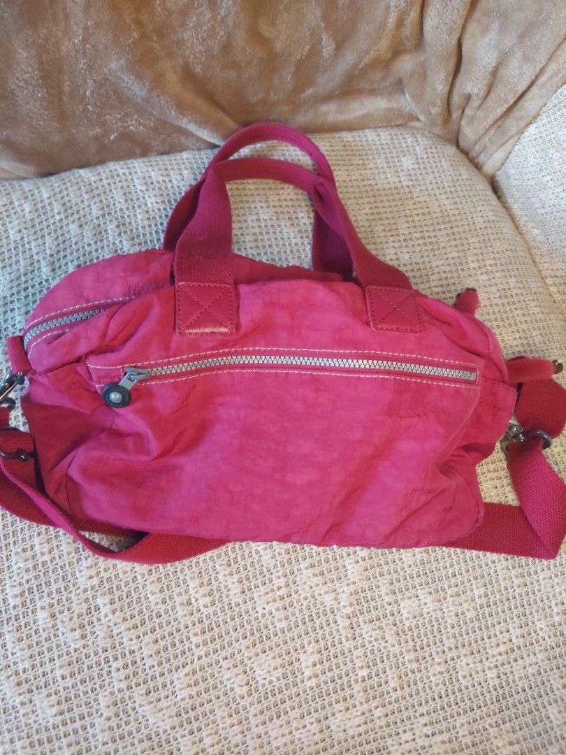 Kipling Pink Nylon Shoulder Bag Handbag (Category: Shoulder Bags) located in Quezon City. Submitted by never_a_clutter (Listing ID 1469204298, Image 3). Description: - Authentic Kipling shoulder bag in a vibrant bright pink color - Made from durable, signature crinkled nylon - Versatile carry options with dual top handles and an adjustable crossbody strap - Includes the iconic matching furry monkey keychain - Multiple exterior front zip pockets f