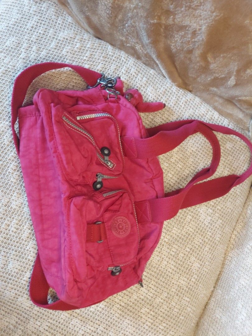 Kipling Pink Nylon Shoulder Bag Handbag (Category: Shoulder Bags) located in Quezon City. Submitted by never_a_clutter (Listing ID 1469204298, Image 1). Description: - Authentic Kipling shoulder bag in a vibrant bright pink color - Made from durable, signature crinkled nylon - Versatile carry options with dual top handles and an adjustable crossbody strap - Includes the iconic matching furry monkey keychain - Multiple exterior front zip pockets f