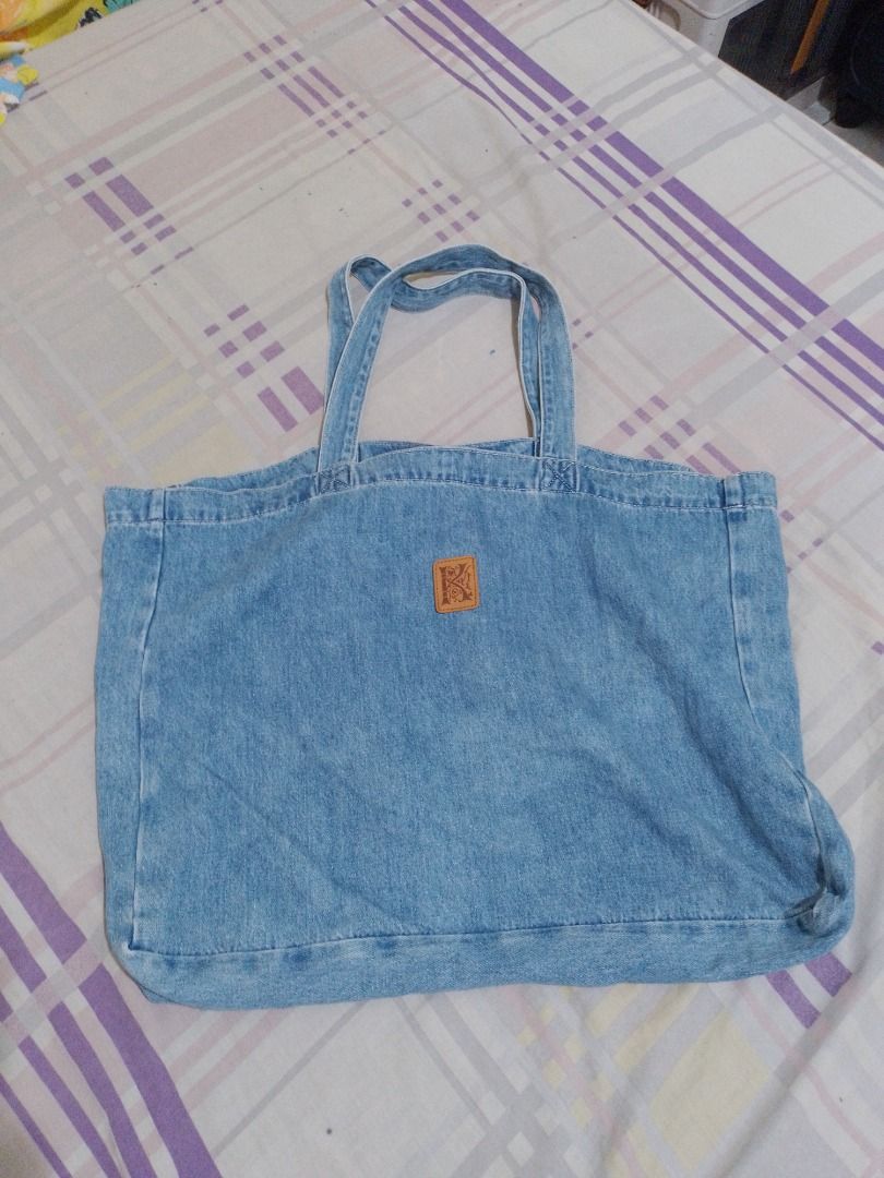 Kokia Denim Tote Bag with Embroidered Monogram and Patch (Category: Tote Bags) located in Imus. Submitted by bestfinds_yeth0724 (Listing ID 1469379836, Image 2). Description: - Brand: Kokia - Material: 100% cotton denim in light blue wash - Design: White embroidered monogram on the front and brown leather patch with embossed 'K' on the back - Closure: Secure magnetic snap - Carry: Double top handles - Features: Roomy interior, perfect for daily u