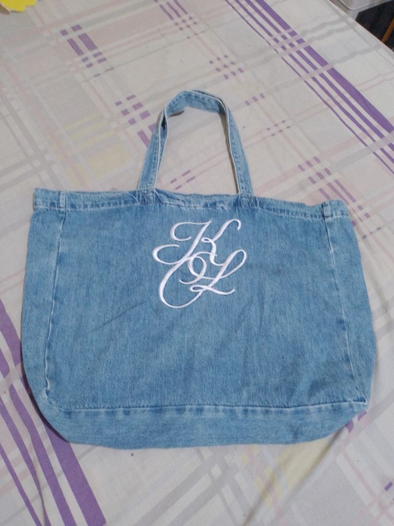 Kokia Denim Tote Bag with Embroidered Monogram and Patch (Category: Tote Bags) located in Imus. Submitted by bestfinds_yeth0724 (Listing ID 1469379836, Image 1). Description: - Brand: Kokia - Material: 100% cotton denim in light blue wash - Design: White embroidered monogram on the front and brown leather patch with embossed 'K' on the back - Closure: Secure magnetic snap - Carry: Double top handles - Features: Roomy interior, perfect for daily u