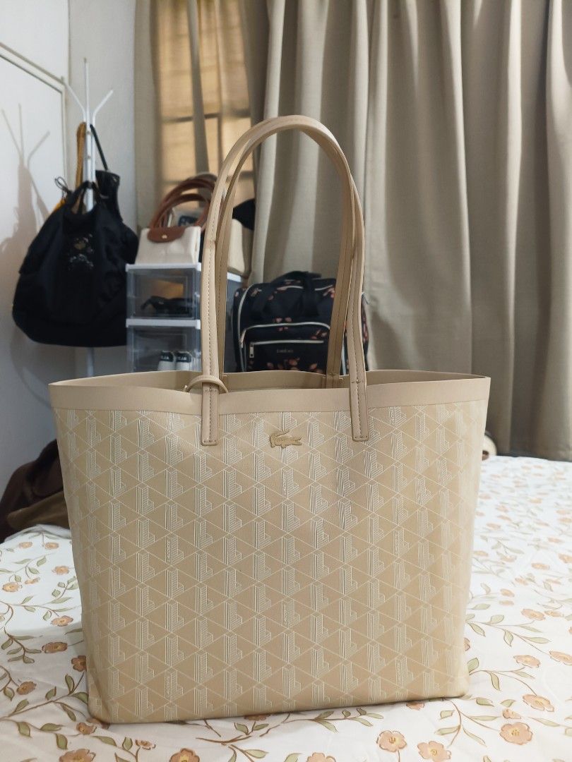 Lacoste Beige Tote Bag With Pouch (Category: Tote Bags) located in Baguio. Submitted by maria.s0329822318 (Listing ID 1469222810, Image 1). Description: - Brand: Lacoste - Color/Design: Beige with all-over geometric monogram print - Features: Signature metal crocodile logo on the front, structured shape, and dual shoulder handles - Organization: Multiple interior compartments to keep your essentials organized - Inclusion: Comes with a matching zi