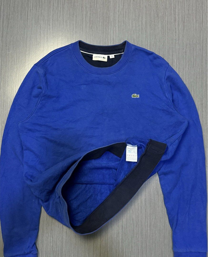 Lacoste Blue Sweatshirt Crewneck (Category: Coats, Jackets and Outerwear) located in Caloocan City. Submitted by mzcollection_349 (Listing ID 1469245077, Image 2). Description: - Authentic Lacoste crewneck sweatshirt in a vibrant bright blue - Features the iconic embroidered crocodile logo on the chest - Classic ribbed collar, cuffs, and hem for a secure fit - Pit to pit: 21.5 inches | Length: 26.5 inches - Versatile everyday staple, perfect for 