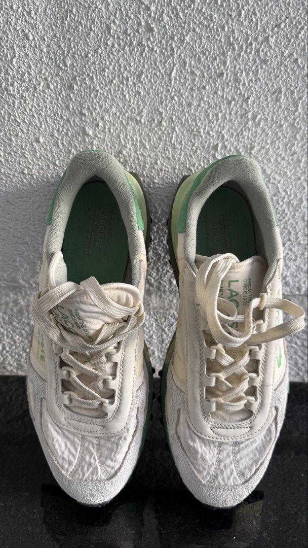 Lacoste Elite Active (Category: Sneakers) located in Pasig City. Submitted by byz94 (Listing ID 1469168314, Image 3). Description: White and green Lacoste sneakers with suede panels and chunky treaded rubber soles. Branding printed on the side panel and tongue. Coordinates text printed along the midsole and upper. Textured nylon upper material. Grippy black outsole with green and cream accents. Laced front closure with flat woven laces..