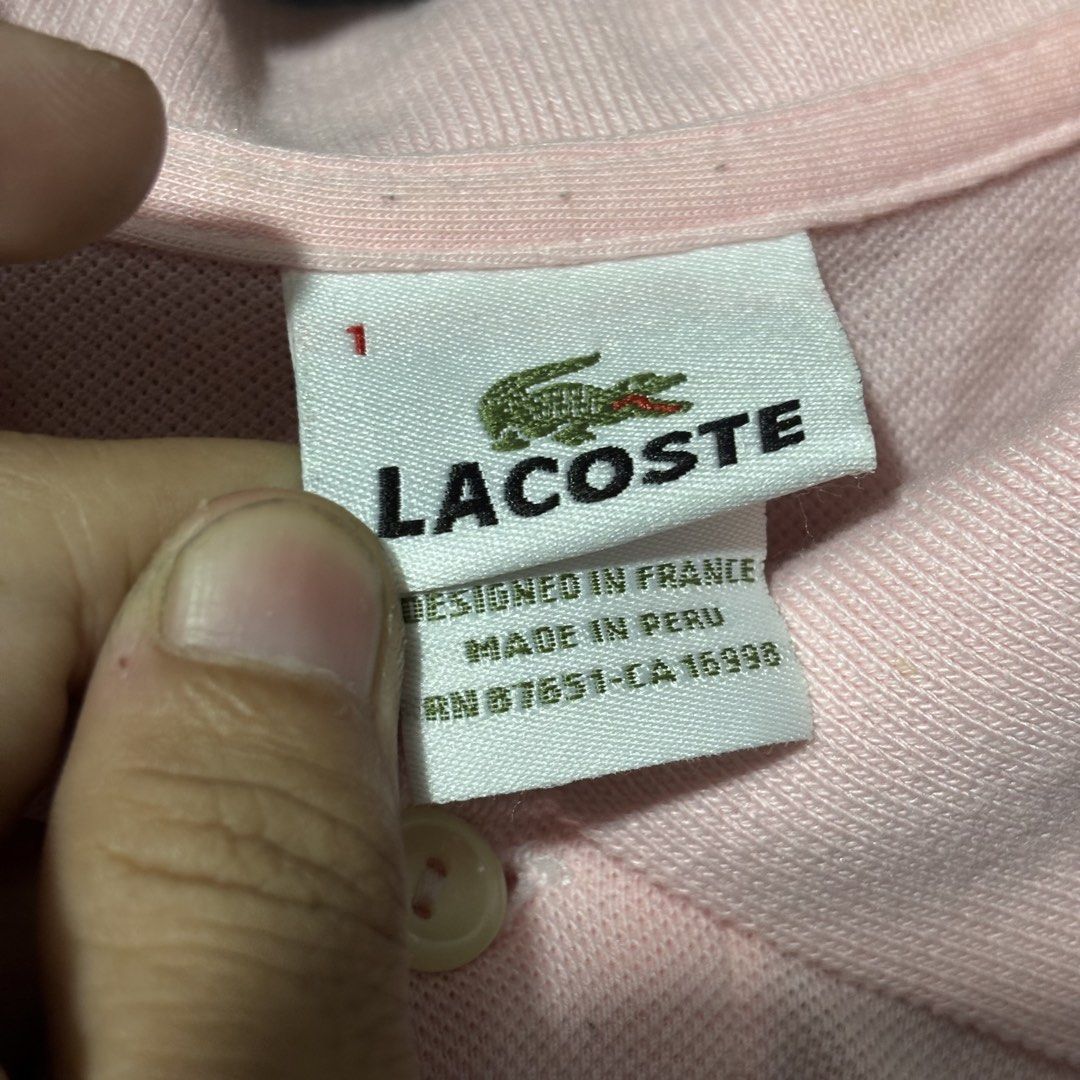 Lacoste Pink Polo Shirt Size 1 (Category: Tshirts & Polo Shirts ) located in Caloocan City. Submitted by bonsatocha43876 (Listing ID 1469314396, Image 2). Description: - Brand: Lacoste - Style: Short-sleeve polo with classic button placket and embroidered green crocodile logo - Size: 1 (Measures 21" across chest, 25" in length) - Material: 100% cotton, Made in Peru - Condition: Authentic with original tags, but has visible fading and marks on the
