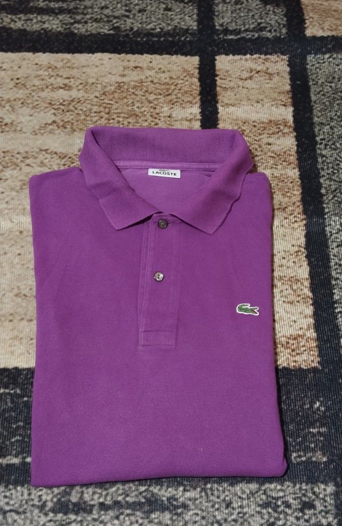 Lacoste Purple Polo Shirt (Category: Tshirts & Polo Shirts ) located in Manila. Submitted by ianmontede19006 (Listing ID 1469336313, Image 1). Description: - Brand: Lacoste (Manufactured by Devanlay) - Color: Vibrant Purple - Material: 100% classic cotton piqué - Design: Short sleeves, standard collar, two-button placket with dark buttons - Detail: Iconic green crocodile logo embroidered on the chest - Condition: Clean inside label, well-maintain