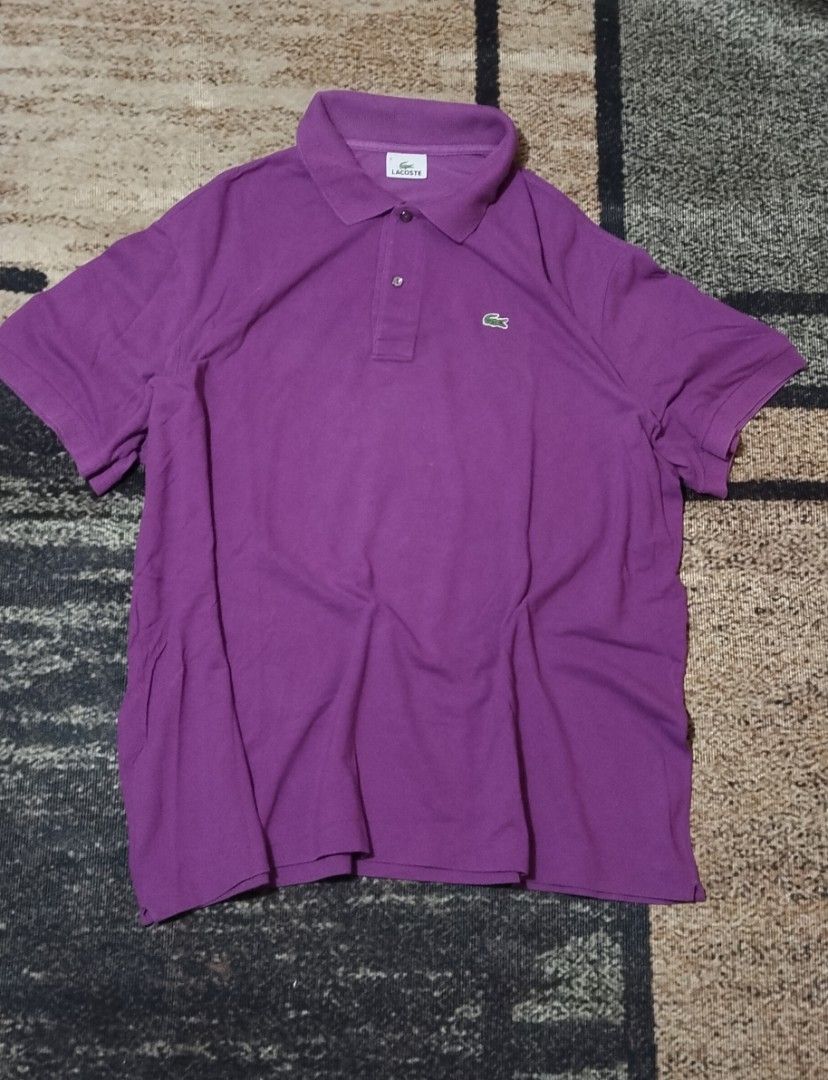 Lacoste Purple Polo Shirt (Category: Tshirts & Polo Shirts ) located in Manila. Submitted by ianmontede19006 (Listing ID 1469336313, Image 2). Description: - Brand: Lacoste (Manufactured by Devanlay) - Color: Vibrant Purple - Material: 100% classic cotton piqué - Design: Short sleeves, standard collar, two-button placket with dark buttons - Detail: Iconic green crocodile logo embroidered on the chest - Condition: Clean inside label, well-maintain