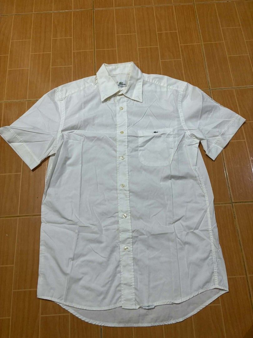 Lacoste White Button-Up Shirt Size 39 (Category: Shirts) located in Paranaque City. Submitted by poego (Listing ID 1469270972, Image 1). Description: - Brand: Lacoste - Style: White button-up shirt / Smart casual & office wear - Size: 39 (Tagged at neck) - Fit: Standard fit - Material: Clean, breathable cotton - Details: Point collar, front button placket, single chest pocket with embroidered crocodile logo, branded mother-of-pearl buttons - Cond