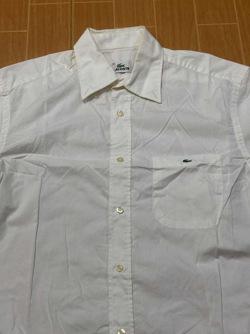 Lacoste White Button-Up Shirt Size 39 (Category: Shirts) located in Paranaque City. Submitted by poego (Listing ID 1469270972, Image 2). Description: - Brand: Lacoste - Style: White button-up shirt / Smart casual & office wear - Size: 39 (Tagged at neck) - Fit: Standard fit - Material: Clean, breathable cotton - Details: Point collar, front button placket, single chest pocket with embroidered crocodile logo, branded mother-of-pearl buttons - Cond