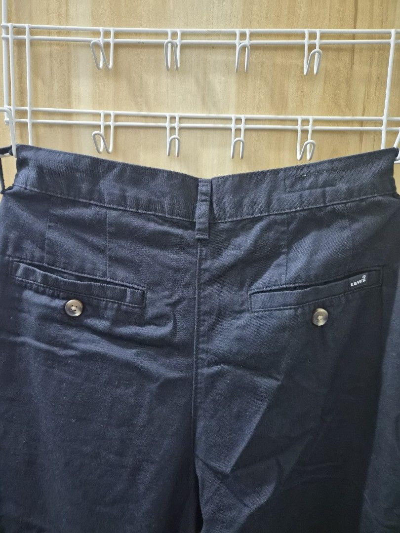 Levi's Black Casual Pants Trousers (Category: Jeans) located in Mandaluyong City. Submitted by joyce1593 (Listing ID 1469255585, Image 2). Description: - Brand: Levi's - Colors available: Dark navy or black - Closure: Button closure with zip fly - Design: Front pleats with a clean, classic straight fit - Pockets: Back welt pockets with button closures and iconic small Levi's brand tag - Condition: Clean fabric throughout.