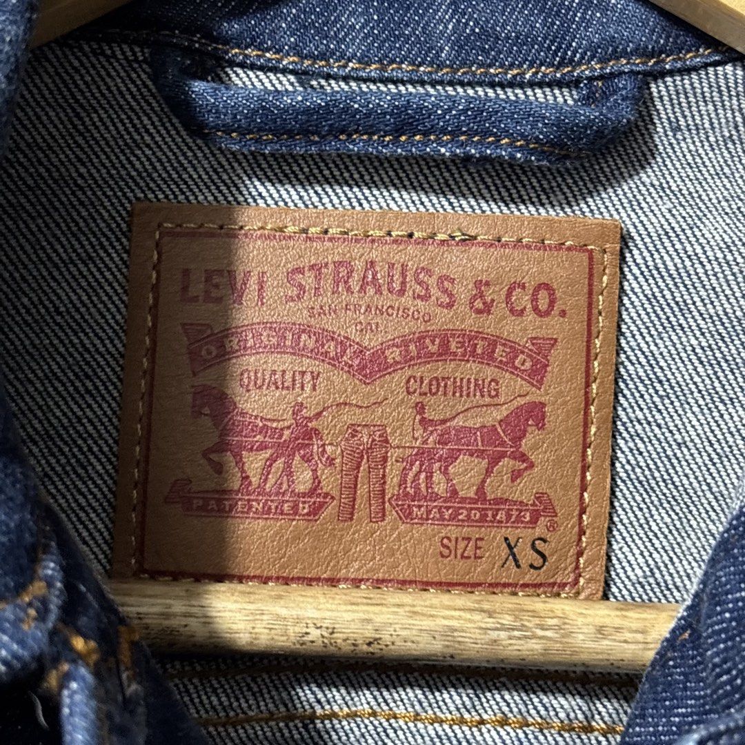Levi's Denim Jacket Size XS (Category: Coats, Jackets and Outerwear) located in Caloocan City. Submitted by bonsatocha43876 (Listing ID 1469322577, Image 3). Description: - Brand: Levi's - Color/Wash: Dark wash denim - Size: XS (tag on inner collar) - Dimensions: 17" width, 19" length - Features: Classic button-up front, dual chest pockets, and side pockets - Condition: Great staple piece for layering, complete with inner laundry tags.