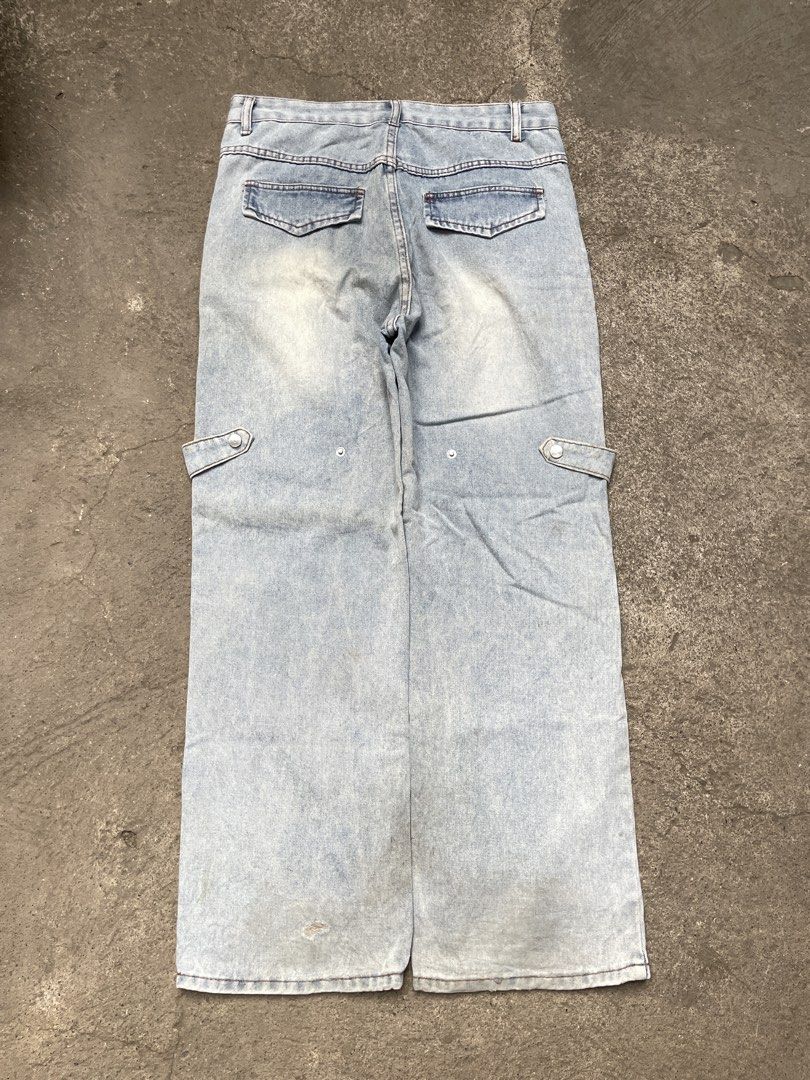 Light wash panel cargo denim jeans wide leg (Category: Jeans) located in Davao. Submitted by riab_qt (Listing ID 1469213853, Image 3). Description: - Style: Light wash wide-leg denim with unique geometric seams and paneled construction - Details: Cargo pockets, flap back pockets, and straight hem openings - Measurements: Waist 33", Length 42", Hem 9" - Condition: Shows minor signs of wear and slight fading throughout.