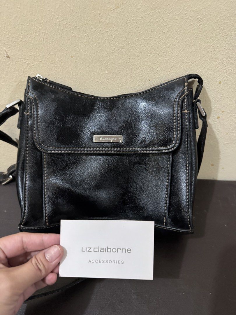 Liz Claiborne Black Shoulder Bag (Category: Shoulder Bags) located in Antipolo. Submitted by angelasanv44409 (Listing ID 1469189204, Image 1). Description: Black shoulder bag from Liz Claiborne Accessories. Front flap pocket with metallic logo plaque. Contrast stitching along the edges. Vibrant red fabric lining inside with an interior zippered pocket. Zipper closure on top. Adjustable black shoulder strap attached with silver hardware..