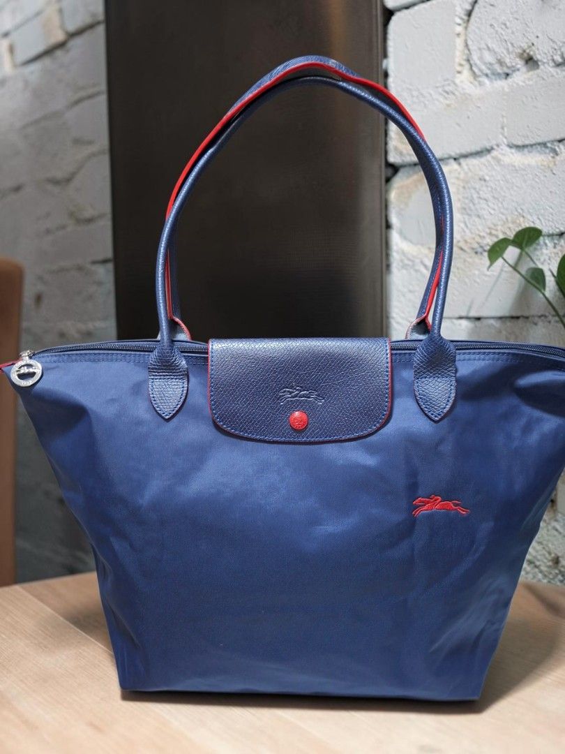LONG CHAMP LE PLIAGE CLUB MEDIUM LONG HANDLE TOTE (Category: Tote Bags) located in Las Pinas. Submitted by annachiaonair2037 (Listing ID 1469280782, Image 2). Description: LONG CHAMP LE PLIAGE CLUB MEDIUM LONG HANDLE FROM JAPAN YKK ZIP NORMAL SIGN IF USAGE, OIN HOLE ON ONE CORNER white cast on one part covered by the flap H 11.5" L 18" W 7.5" Disclaimer: I am not affiliated with, associated with, or authorized by any of the brands featured posted