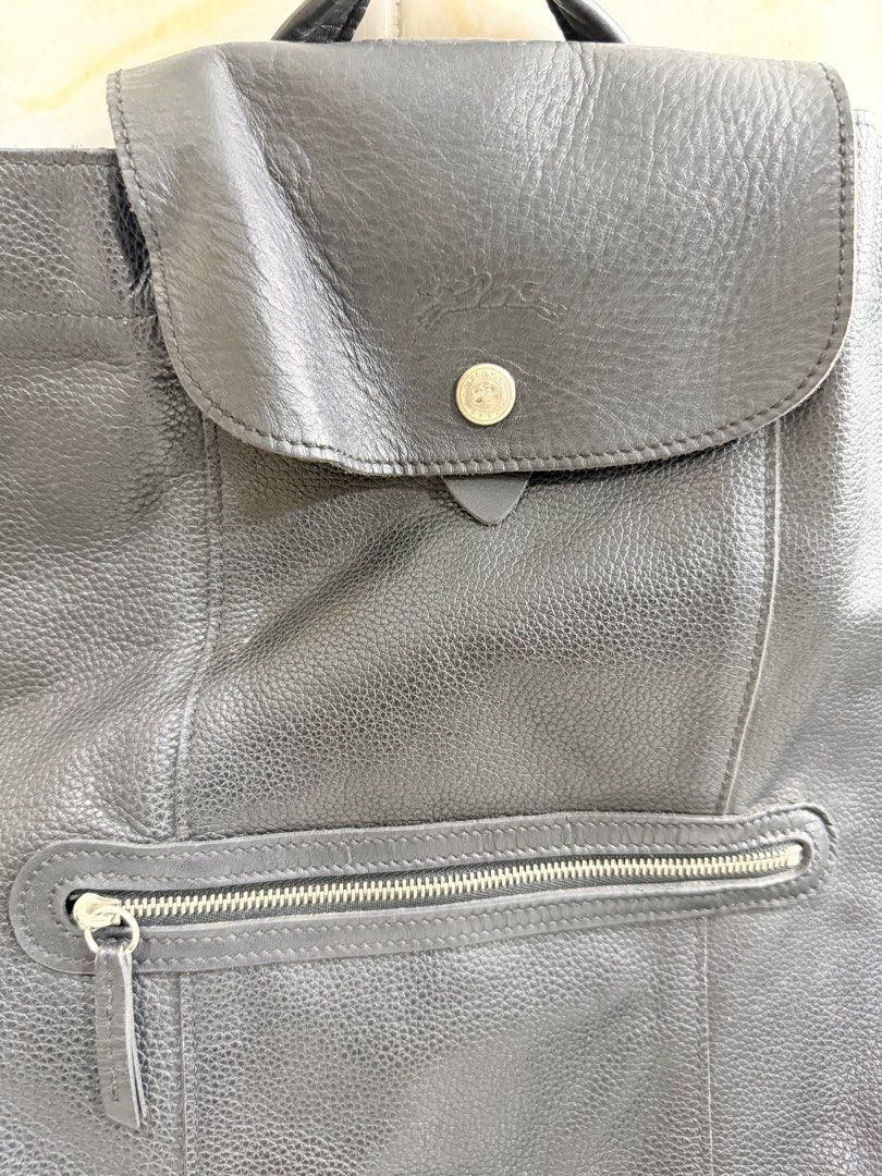 Longchamp Black Leather Backpack (Category: Backpacks) located in Manila. Submitted by haveago0dthrift (Listing ID 1469256246, Image 2). Description: - Brand: Longchamp - Material: Soft pebbled leather with dark hardware - Color: Classic Black - Closure: Top flap with snap button and embossed logo - Pockets: Exterior zipped front pocket and interior open slip pocket - Straps: Adjustable fabric straps with top grab handle - Interior: Signature jac
