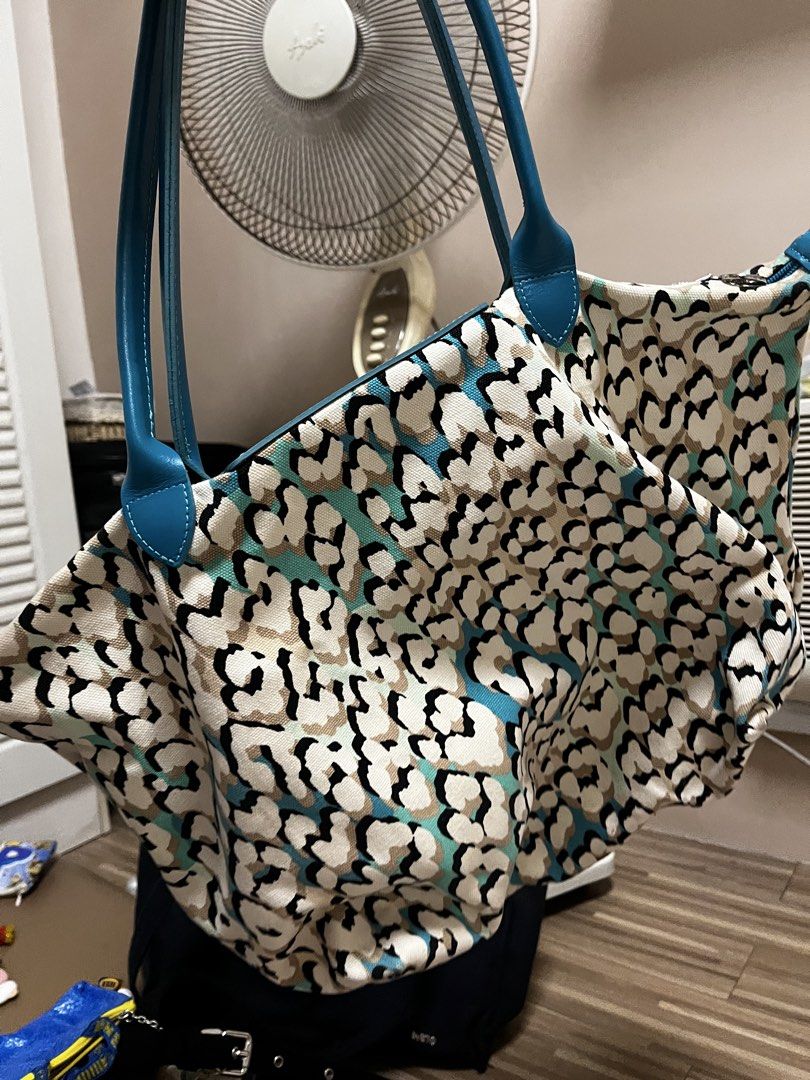 Longchamp Canvas Tote Bag (Category: Tote Bags) located in Cardona. Submitted by minyoonji (Listing ID 1469263575, Image 2). Description: - Brand: Longchamp - Design: All-over animal and leopard print in black, white, beige, and turquoise - Details: Blue leather shoulder handles and front flap closure with silver-tone snap button and embossed horse logo - Interior: Spacious fabric interior with open compartment - Condition: Clean fabric texture w
