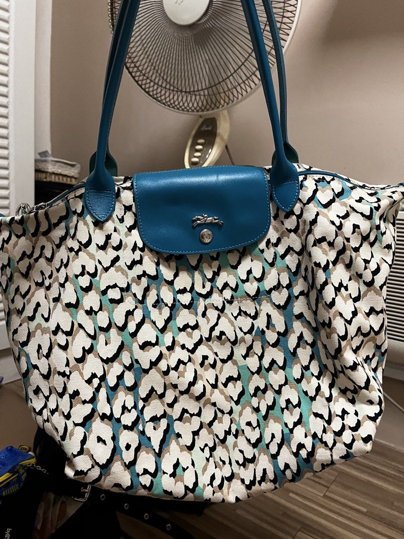 Longchamp Canvas Tote Bag (Category: Tote Bags) located in Cardona. Submitted by minyoonji (Listing ID 1469263575, Image 1). Description: - Brand: Longchamp - Design: All-over animal and leopard print in black, white, beige, and turquoise - Details: Blue leather shoulder handles and front flap closure with silver-tone snap button and embossed horse logo - Interior: Spacious fabric interior with open compartment - Condition: Clean fabric texture w