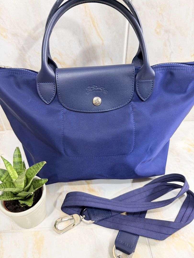Longchamp Le Pliage Neo Blue Two-way Bag (Category: Luxury Bags & Wallets) located in Manila. Submitted by haveago0dthrift (Listing ID 1469256525, Image 2). Description: - Brand: Longchamp Le Pliage Neo - Color: Dark Blue - Material: Durable nylon body with matching leather flap and top handles - Closure: Secure zip closure with snap button - Strap: Removable fabric shoulder strap included - Interior: Clean fabric lining with open pocket and visi
