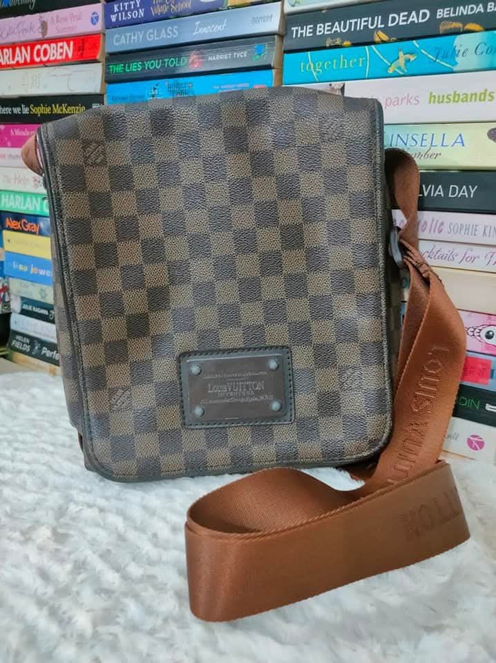 Louis Vuitton Damier Ebene District Messenger Bag (Category: Luxury Bags & Wallets) located in Manila. Submitted by ekailacerna (Listing ID 1469316630, Image 1). Description: - Authentic Louis Vuitton messenger bag in classic Damier Ebene canvas - Durable brown checkered pattern with dark leather front logo patch - Adjustable brown fabric strap with woven Louis Vuitton lettering - Structured shape with secure front flap closure - Clean lines, pra