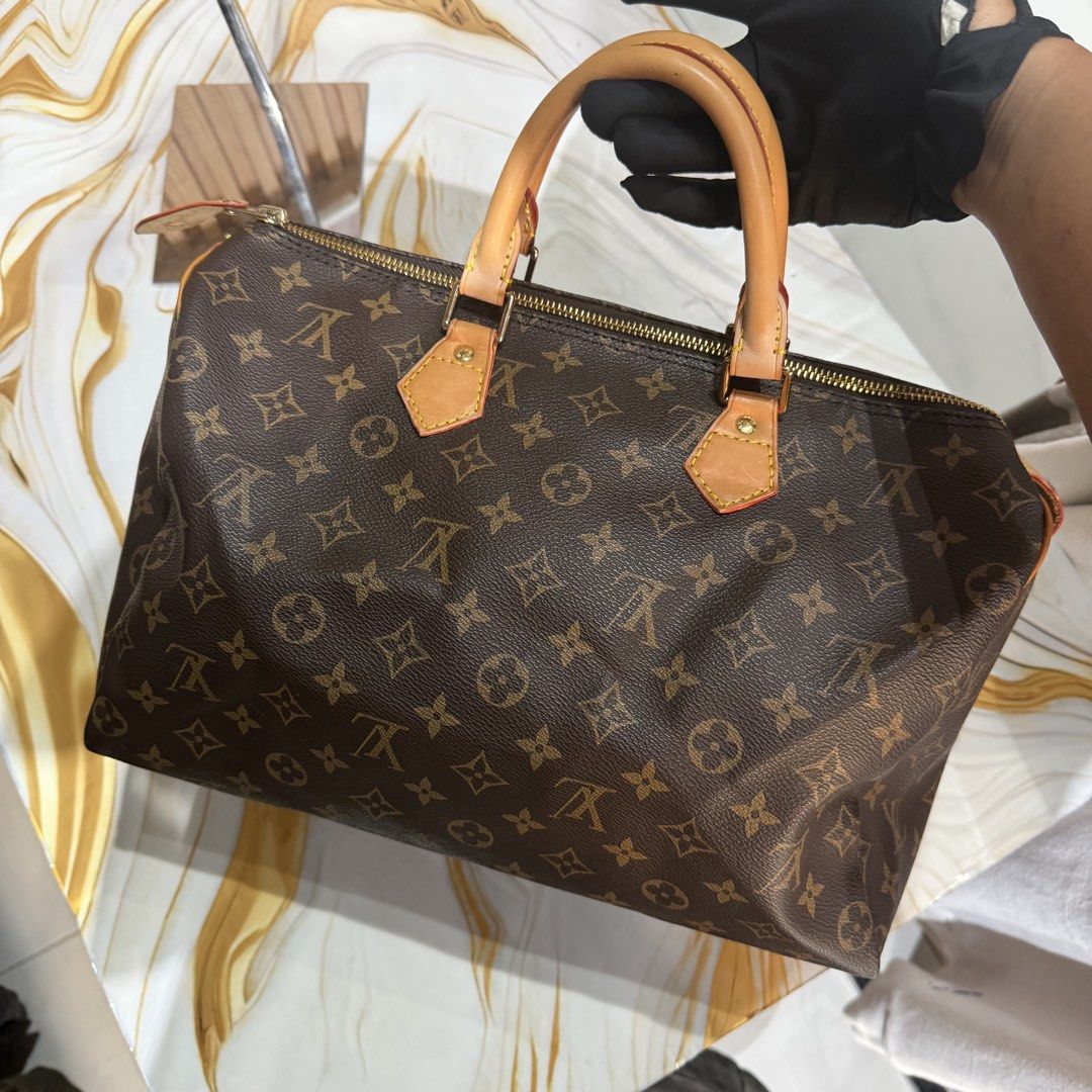 Louis Vuitton Monogram Canvas Speedy 30 Handbag (Category: Luxury Bags & Wallets) located in Bambang. Submitted by heats777 (Listing ID 1469170418, Image 3). Description: Classic Monogram canvas exterior with natural cowhide leather trim. Double rolled top handles, gold-tone hardware, and brown textile lining. Heat stamp reads Louis Vuitton Paris Made in France. Interior leather tab shows model code M41524. Zip closure across the top. Clean stitc