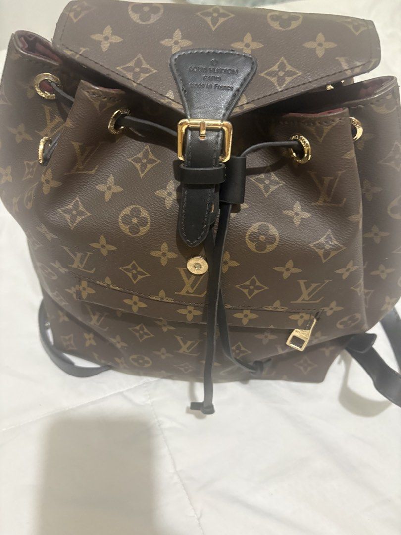 Louis Vuitton Monogram Canvas Backpack (Category: Luxury Bags & Wallets) located in Manila. Submitted by nykji96 (Listing ID 1469191182, Image 1). Description: - Authentic Louis Vuitton monogram canvas backpack - Stylish black leather straps and trim with gold-tone hardware - Secure drawstring closure with front buckle flap - Convenient exterior front zip pocket - Luxurious deep burgundy interior lining - Stamped Louis Vuitton Paris, Made in Fran