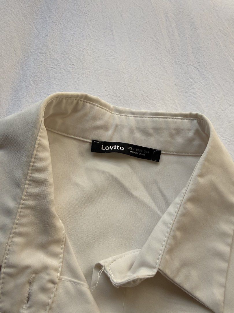 Lovito White Button-Up Collared Shirt (Category: Blouses) located in Manila. Submitted by the.prelovedcloset (Listing ID 1469255697, Image 2). Description: - Brand: Lovito - Color: Plain white - Style: Button-up shirt with classic collar and front button placket - Material: Lightweight and comfortable fabric - Size: EU 34 / US 4 - Condition: Clean, minimal wear, great everyday basic.