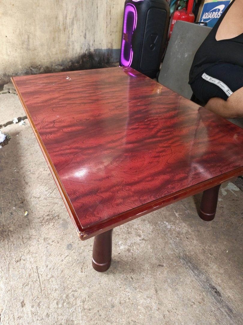 Low table japan surplus (Category: Tables & Sets) located in Manila. Submitted by aks_japansurplus30 (Listing ID 1469200144, Image 3). Description: - Type: Low wooden table / Floor seating table - Finish: Glossy reddish woodgrain top with smooth rounded edges - Legs: Dark brown turned legs with foldable metal brackets for easy storage - Condition: Sturdy and stable, with minor wear around the corner edges - Ideal for: Low living room setups, coff