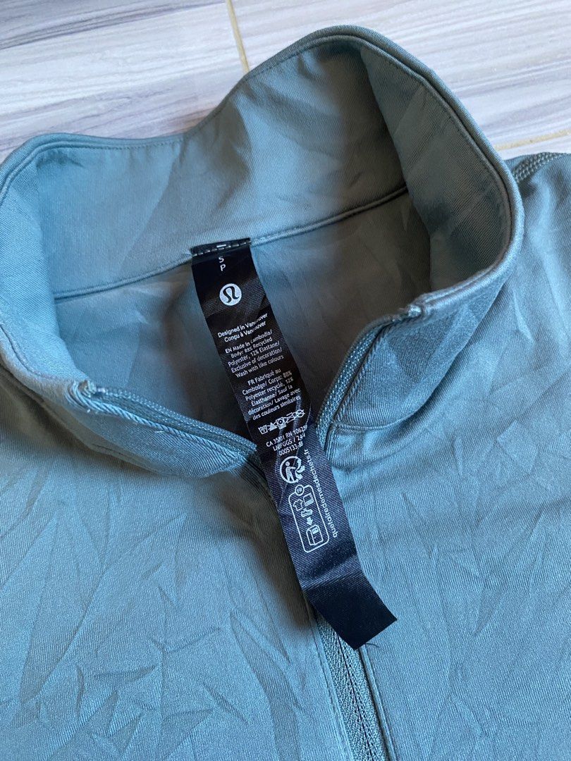Lululemon Metal Vent Tech 1/2 Zip Pullover (Category: Activewear) located in Bayambang. Submitted by vintagestuffph (Listing ID 1469199380, Image 3). Description: - Brand: Lululemon - Style: Half-zip pullover with stand-up collar - Color: Muted blue-grey - Size: S (tag intact) - Material: Recycled polyester and elastane blend for comfortable stretch - Details: Small reflective logo on the lower back hem.
