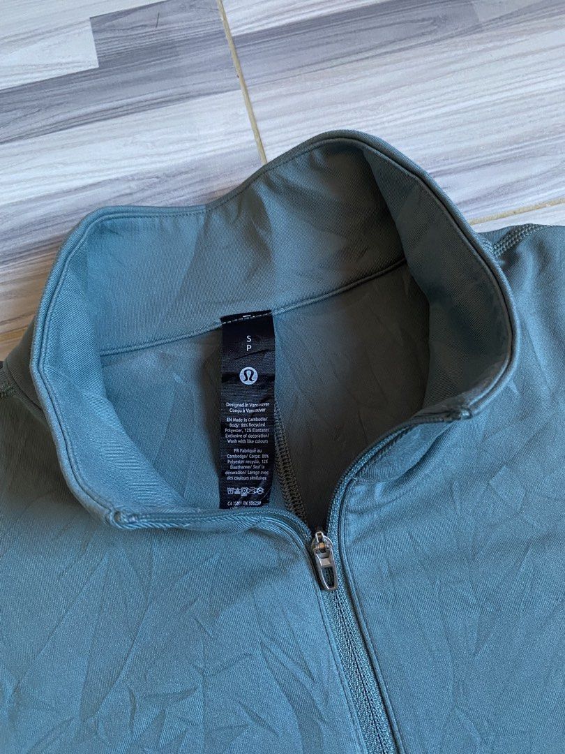 Lululemon Metal Vent Tech 1/2 Zip Pullover (Category: Activewear) located in Bayambang. Submitted by vintagestuffph (Listing ID 1469199380, Image 2). Description: - Brand: Lululemon - Style: Half-zip pullover with stand-up collar - Color: Muted blue-grey - Size: S (tag intact) - Material: Recycled polyester and elastane blend for comfortable stretch - Details: Small reflective logo on the lower back hem.