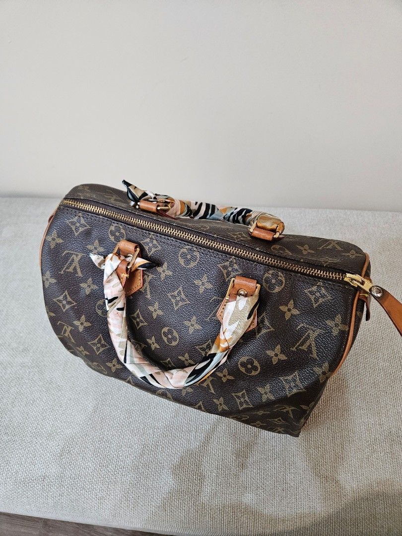 LV Monogram Speedy (Category: Luxury Bags & Wallets) located in Quezon City. Submitted by andyrms (Listing ID 1469208205, Image 3). Description: - Bought in Japan - Brown coated canvas with LV print and vachetta leather trim - Secure zip closure with classic gold-tone hardware - Clean interior fabric lining with structured shape - Date code: SP0028 stamped inside - Comes with a stylish twilly scarf wrapped around the top handles - Perfect timeles