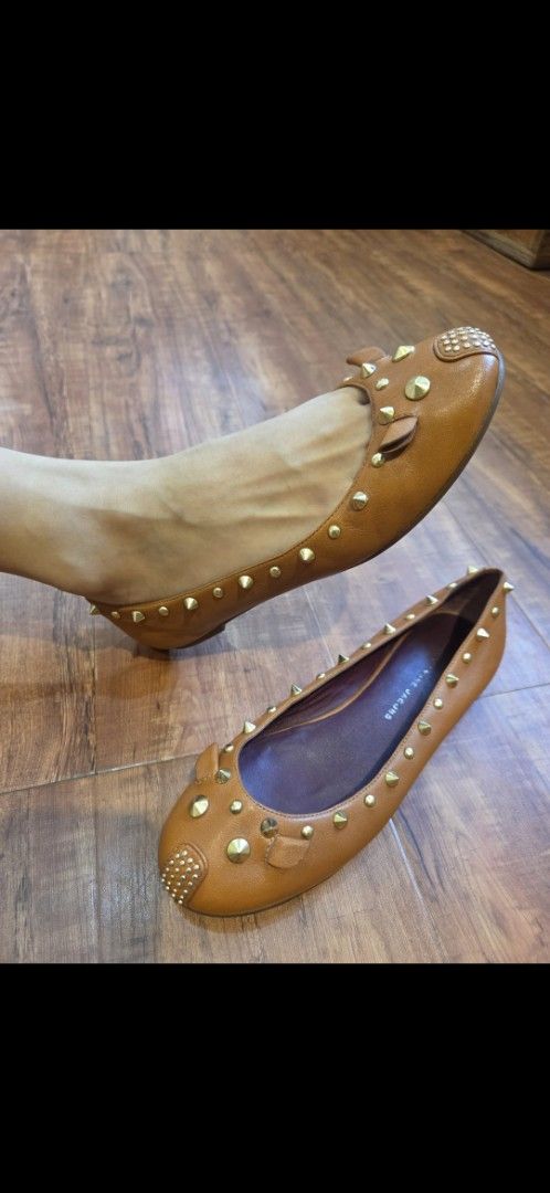 Marc Jacobs Tan Leather Studded Flats (Category: Flats & Sandals) located in Manila. Submitted by mysticrabbit.284012 (Listing ID 1469236337, Image 1). Description: - Brand: Marc Jacobs - Material: Genuine tan leather with wooden sole edge - Details: Gold cone studs along edges and toe cap, delicate bow accents - Interior: Dark purple lining with stamped Marc Jacobs logo - Style: Slip-on flat shoes - Condition: Excellent pre-loved condition - Shi