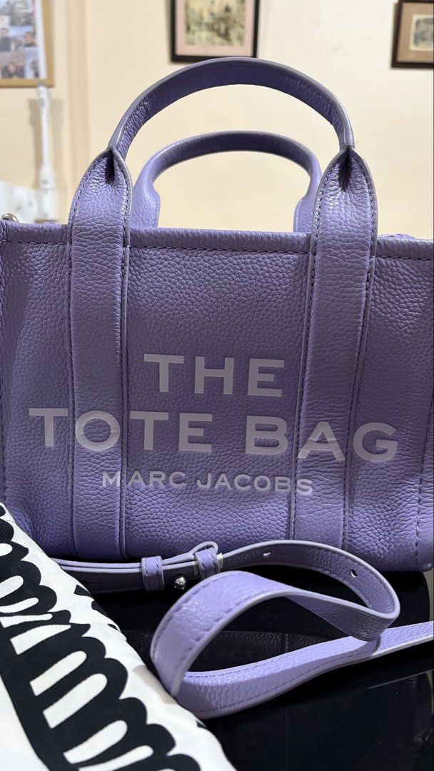 Marc Jacobs The Leather Small Tote Bag Lavender (Category: Luxury Bags & Wallets) located in Quezon City. Submitted by bella_ciao (Listing ID 1469231035, Image 3). Description: - Authentic Marc Jacobs leather tote in lavender purple - Crafted from durable pebbled leather with iconic bold text on the front - Secure zip-top closure with fabric-lined interior and handy pocket - Includes a detachable shoulder strap for crossbody or hand carry - Comes