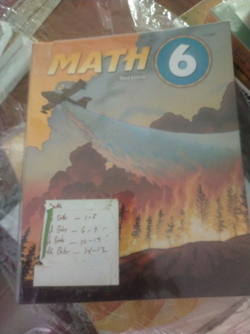 BJU Math 6 Third Edition Textbook (Category: Assessment Books) located in Quezon City. Submitted by bamberry (Listing ID 1469204258, Image 1). Description: BJU Math 6 textbook, third edition. Cover features an airplane flying over a forest fire illustration. Paper sticker on the lower left corner with handwritten notes breaking down quarters 1 through 4 chapters. Solid option for sixth grade math practice or homeschooling needs..