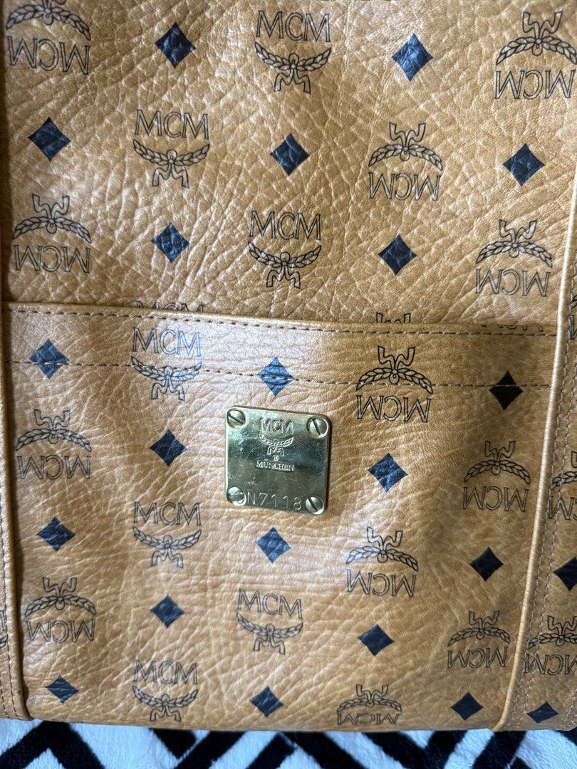 MCM Cognac Visetos Monogram Tote Bag (Category: Luxury Bags & Wallets) located in Pasig City. Submitted by sherill888 (Listing ID 1469338070, Image 3). Description: - Authentic MCM cognac Visetos monogram tote bag - Features double shoulder straps and a structured rectangular silhouette - Convenient front slip pocket with brass-tone logo plate (N7118) - Secure top zipper closure with metallic zipper pull - Crafted from signature coated canvas wit