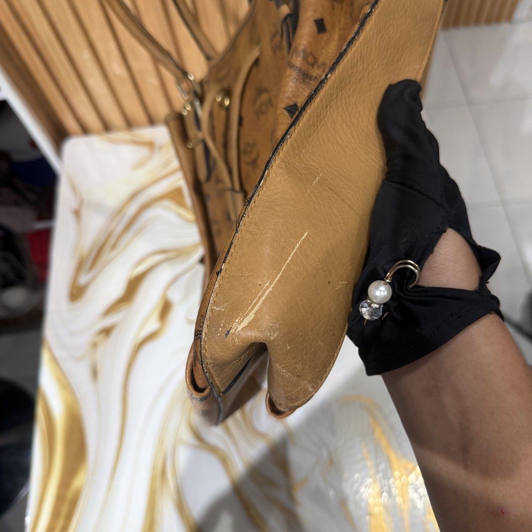 MCM Visetos Brown Monogram Tote Bag (Category: Luxury Bags & Wallets) located in Bambang. Submitted by heats777 (Listing ID 1469169865, Image 2). Description: - Authentic brown MCM Visetos monogram tote bag - Tan leather trim and polished gold-tone hardware - Practical drawstring closure at the front - Double top handles with adjustable buckles - Roomy interior, perfect for daily use - Condition: Regular wear along edges and scuff marks on the bo