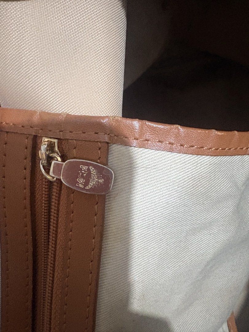 MCM Visetos Monogram Tote Bag Brown (Category: Luxury Bags & Wallets) located in Manila. Submitted by nykji96 (Listing ID 1469191086, Image 3). Description: - Authentic MCM brown monogram tote bag - Tan leather handles with gold-tone hardware - Includes a charming bone charm on a beaded chain - Secure zip top closure - Fabric-lined interior with a convenient zippered pocket - Condition note: Visible signs of wear along the top edges, base corners