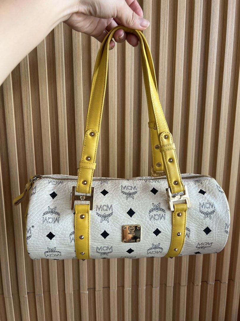 MCM White and Yellow Monogram Barrel Shoulder Bag (Category: Luxury Bags & Wallets) located in Lipa City. Submitted by thyra06 (Listing ID 1469241989, Image 2). Description: - Brand: MCM - Style: Barrel bag with distinct cylindrical shape - Color/Pattern: Classic white monogram print with bright yellow leather straps and trim - Hardware: Gold-tone with stylish stud accents and front logo plaque - Features: Dual shoulder straps, secure top zip clo