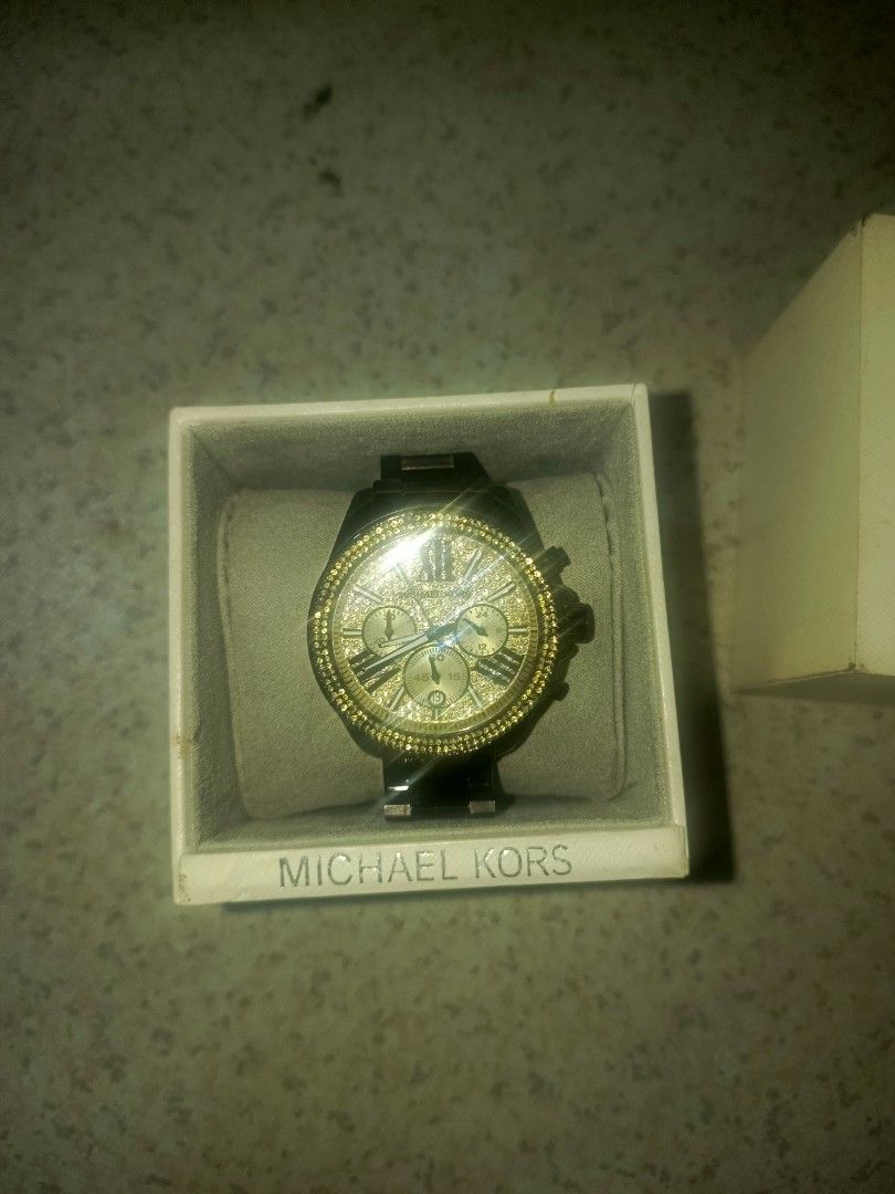 Michael Kors Chronograph Crystal Bezel Watch with Box (Category: Women's Watches) located in Manila. Submitted by john_gubat (Listing ID 1469291341, Image 1). Description: - Brand: Michael Kors - Colorway: Luxurious black and gold with dark metal bracelet - Design: Sparkly crystal bezel, sparkly gold dial face, 3 sub-dials, and date window - Condition: Battery working, keeps accurate time, minimal wear on the band - Inclusion: Original Michael Ko
