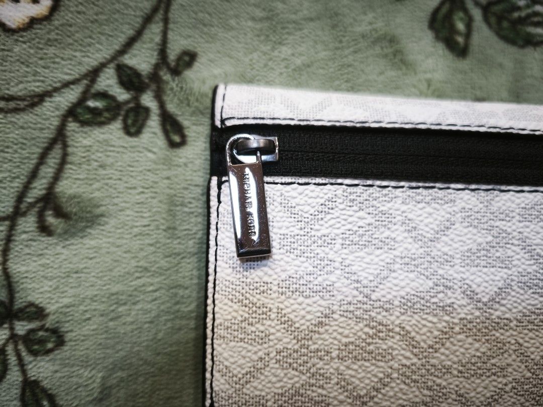 Michael Kors Cooper Slim Bifole Card Case Bright White (Category: Luxury Bags & Wallets) located in Baguio. Submitted by zia_zab (Listing ID 1469257213, Image 3). Description: - Brand: Michael Kors - Model: Cooper Folding Card Case - Color: Bright white monogram with black interior - Condition: Brand new with original tag attached, unworn - Features: Multiple card slots, secure snap button closure, and external zip pocket with branded zipper pull