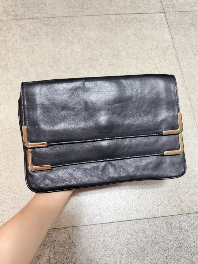 Michael Kors Double-Flap Leather Clutch (Category: Luxury Bags & Wallets) located in Malabon City. Submitted by angelamaclan (Listing ID 1469243475, Image 1). Description: Black leather clutch bag from Michael Kors. Double flap closure secured with a magnetic snap button. The back features a metal Michael Kors logo plaque. Soft leather texture with minimal wear..