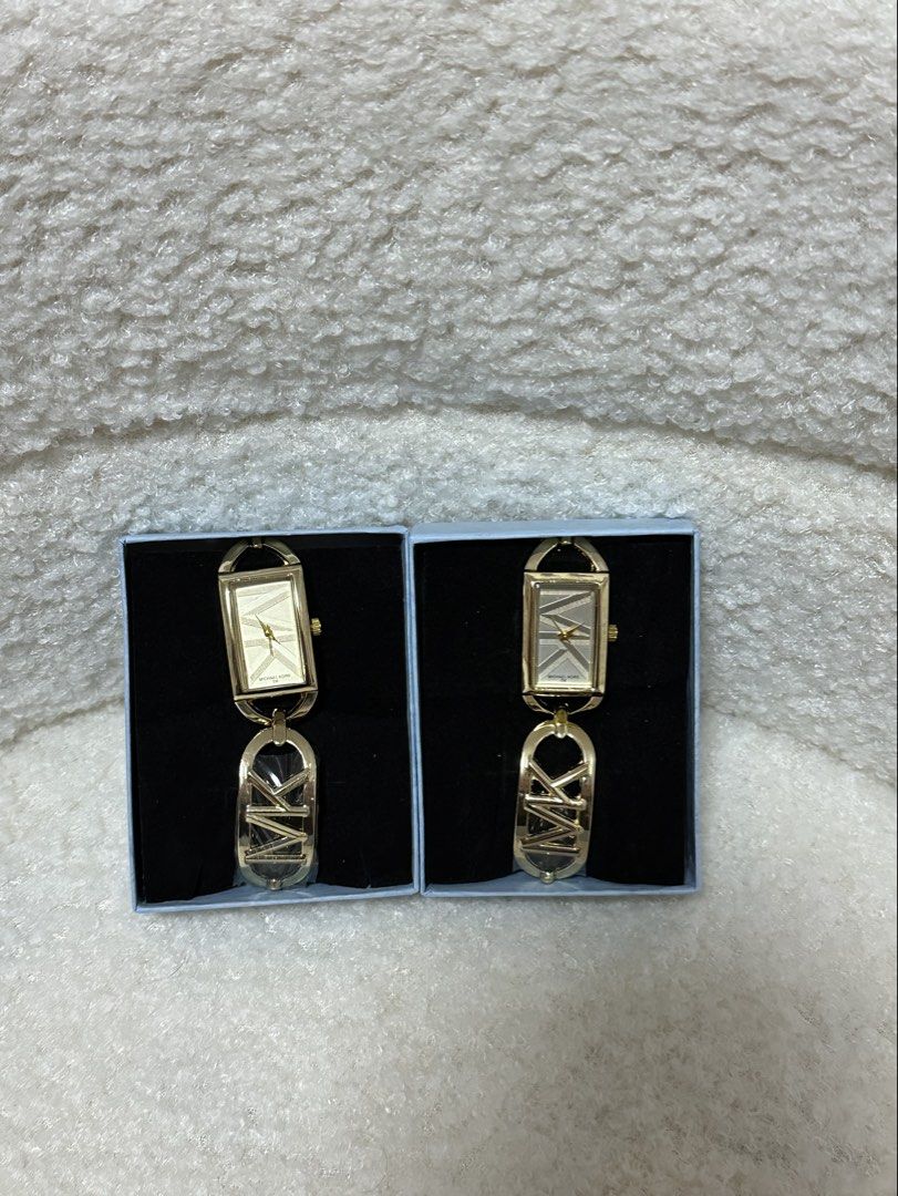 Michael Kors Gold Watch Two Options Available (Category: Women's Watches) located in Manila. Submitted by jmdrgooddeals (Listing ID 1469279855, Image 1). Description: - Michael Kors gold-tone watches - Elegant rectangular face with textured dial design - Matching MK link bracelet strap - Pristine condition with protective plastic still on hardware - Ideal matching gift idea - ₱399 each (₱699 for 2).
