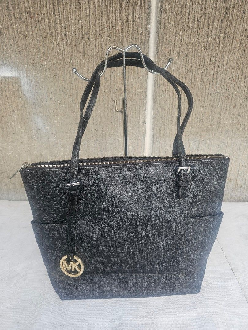 Michael kors jetset tote bag (Category: Tote Bags) located in Manila. Submitted by onlinesmartshopping12 (Listing ID 1469380456, Image 1). Description: Black Michael Kors tote bag. Features a top handle design with a zip closure. Includes exterior pockets and a prominent MK logo. The interior tag indicates it was made in Thailand..