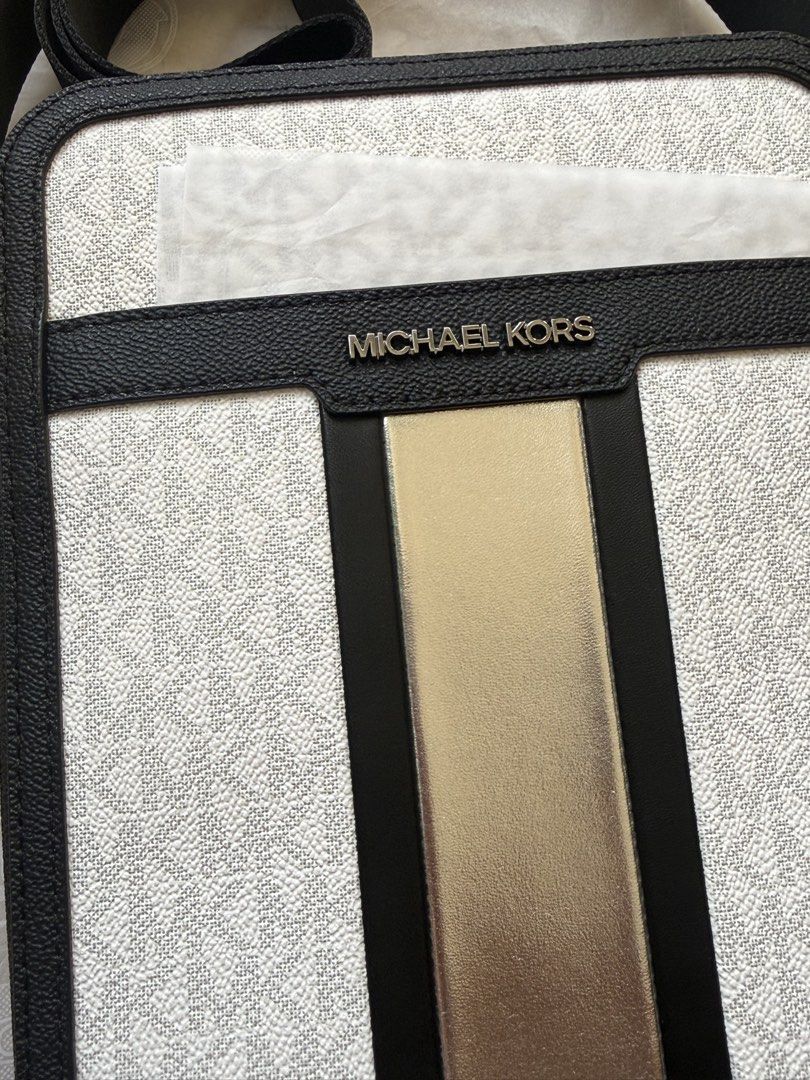 Michael Kors MEN Cooper Flight crossbody bag (Category: Sling Bags) located in San Pedro. Submitted by moonllax (Listing ID 1469237107, Image 2). Description: - Authentic Michael Kors crossbody bag - White and black signature logo canvas with black leather trim - Eye-catching metallic gold vertical center stripe - Silver-tone hardware and front metal logo lettering - Comfortable adjustable black canvas strap - Brand new with original tag attached